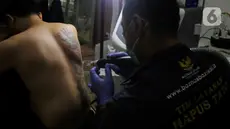 Petugas menghapus tato peserta menggunakan sinar laser di Balai Kota DKI Jakarta, Selasa (11/3/2025). (LIputan6.com/Herman Zakharia)