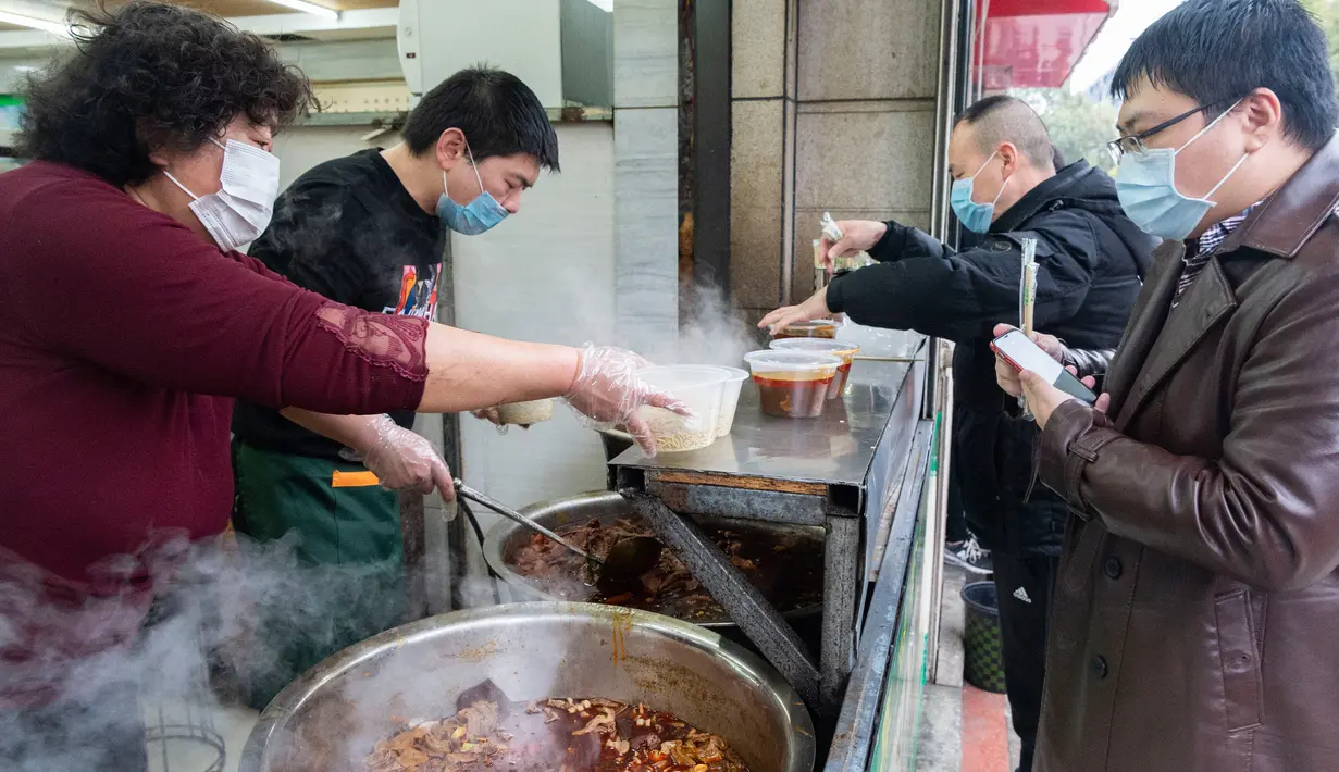 Para pelanggan membeli mi sapi di sebuah restoran di Xiangyang, Provinsi Hubei, China tengah, pada 16 Maret 2020. Beberapa restoran mi sapi di Xiangyang kembali melanjutkan bisnis dengan layanan take away pada Senin (16/3). (Xinhua/Xie Jianfei)
