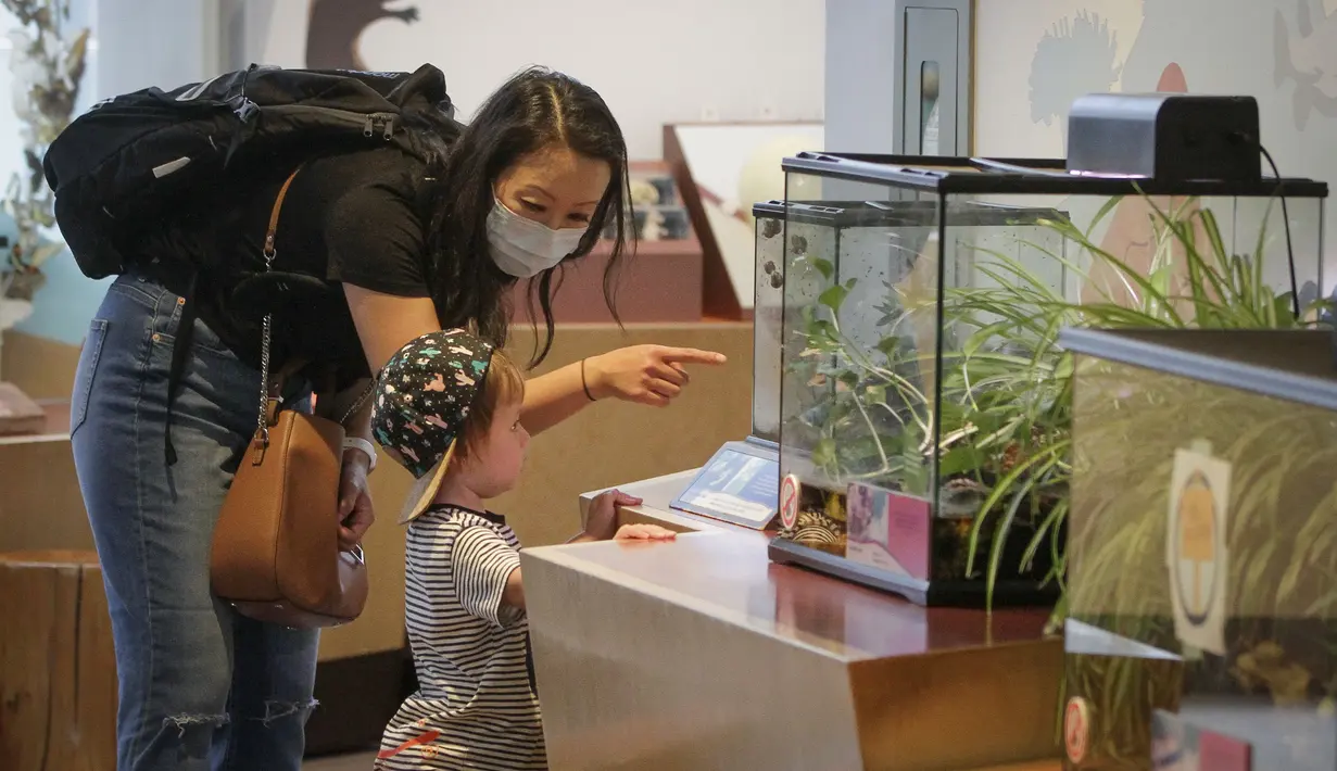 Seorang pekerja garis depan dan anaknya mengunjungi Science World di Vancouver, British Columbia, Kanada (23/7/2020). Science World Vancouver menawarkan tiket masuk gratis bagi para pekerja yang berjuang di garis depan melawan pandemi COVID-19 dan anggota keluarga mereka. (Xinhua/Liang Sen)