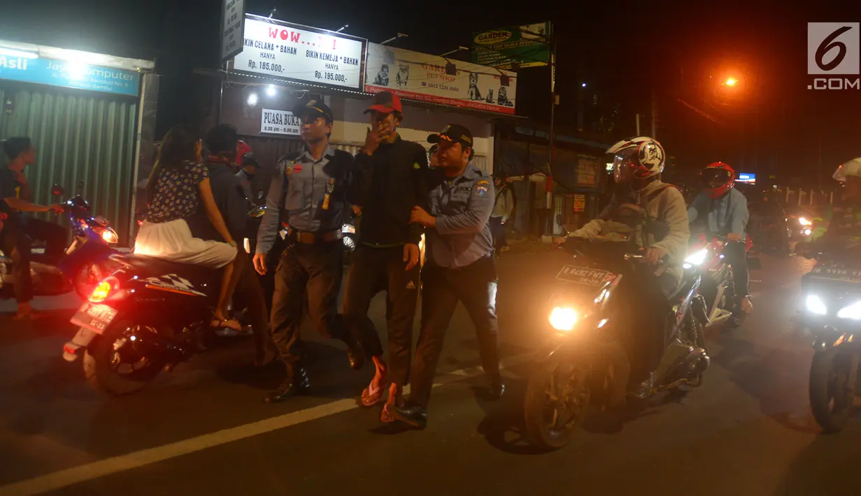 Petugas gabungan melakukan razia terhadap pengamen di kawasan Duren Sawit, Jakarta, Jumat (25/5). Razia tersebut digelar pada malam hari guna memudahkan penangkapan warga yang bekerja sebagai waria, pemulung hingga pengamen. (Merdeka.com/Imam Buhori)