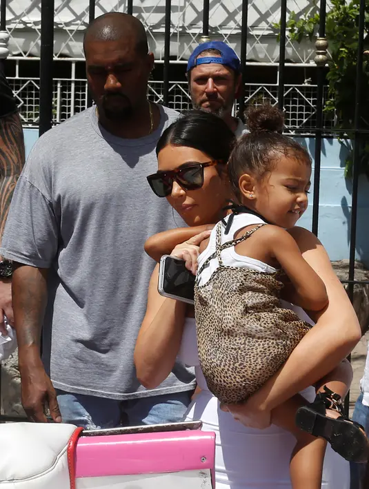 Musisi Kanye menemani istrinya Kim Kardashian dan putri saat ingin naik mobil kuno setelah meninggalkan sebuah restoran di Havana, Cuba, 5 Mei 2016. (REUTERS / Stringer)