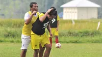 Asisten pelatih Arema FC, Kuncoro (kiri) sedang bercanda dengan Hanif Sjahbandi saat latihan. (Bola.com/Iwan Setiawan)