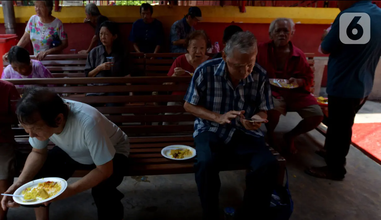 Warga menyantap makan siang di warung nasi kuning Podjok Halal yang berada di Vihara Kim Tek Ie, Petak Sembilan, Jakarta, Selasa (24/12/2019). Warung Podjok Halal tidak memandang etnis dan agama pembelinya, yang penting makan dengan antre dan tertib. (merdeka.com/Imam Buhori)