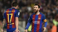 Bintang Barcelona Lionel Messi menghampiri Paco Alcacer usai kolaborasinya membuahkan gol ke gawang Real Sociedad. (LLUIS GENE / AFP)