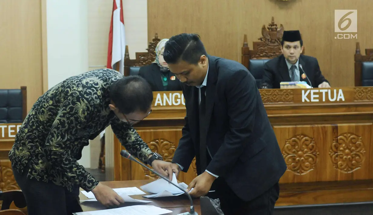 Asisten bantuan hukum LBH Jakarta, Abraham Nempung (kiri) memeriksa berkas saat sidang perdana sengketa informasi publik terhadap Kementerian LHK di Gedung KIP, Jakarta, Kamis (1/3). Sidang beragendakan pemeriksaan awal. (Liputan6.com/Helmi Fithriansyah)