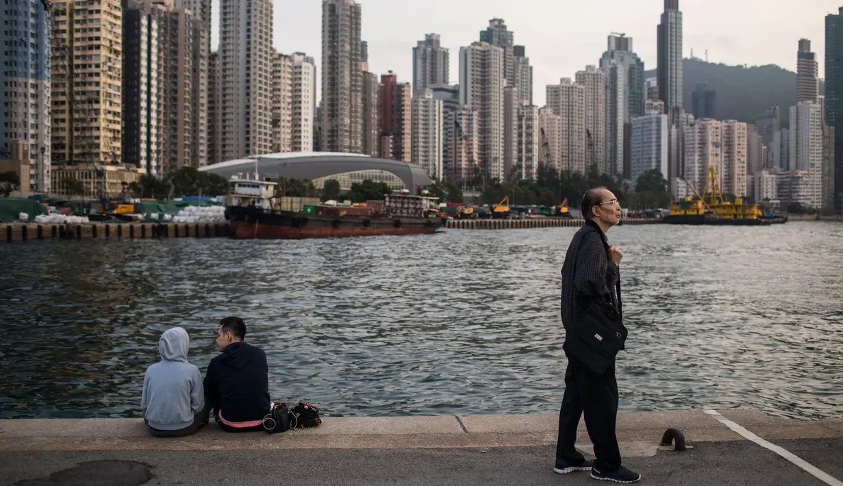 Orang-orang bersantai di dermaga umum di sebelah Pelabuhan Victoria di Hong Kong (3/3). Pemandangan yang spektakuler membuat pelabuhan ini menjadi daya tarik wisata utama Hong Kong. (AFP Photo/Dale De La Rey)