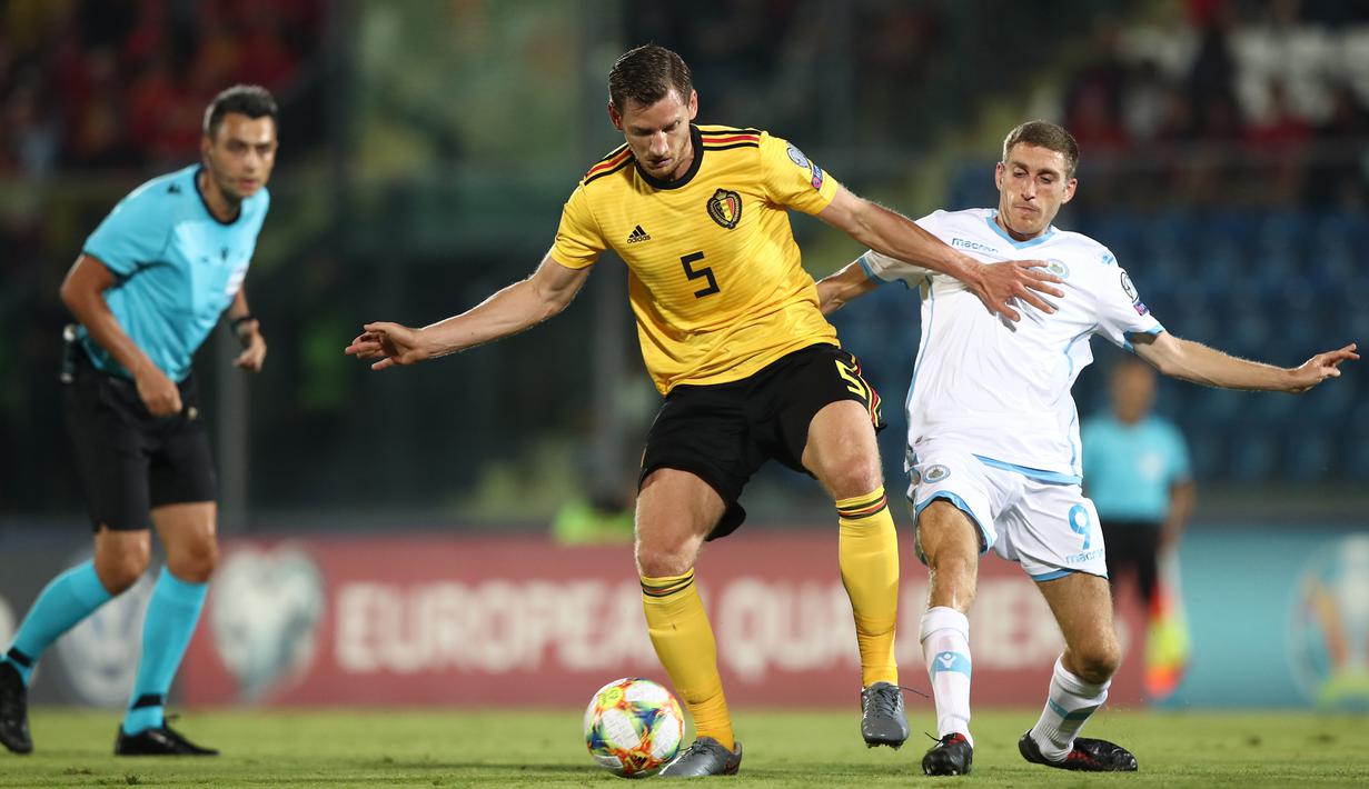 Bek Belgia, Jan Vertonghen, berebut bola dengan gelandang San Marino, Marcello Mularoni, pada laga Kualifikasi Piala Dunia 2022 di Olympic Stadium, Serravalle, Jumat (6/9). San Marino kalah 0-4 dari Belgia. (AFP/Isabella Bonotto)