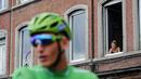 Seorang wanita menonton dari jendela saat pebalap Jerman, Marcel Kittel meraih jersey hijau pada etape ketiga Tour de France dari Verviers, Belgia dan finish di Longwy, Prancis, (3/7/2017). (AP/Christophe Ena)