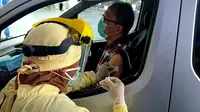 Warga lansia menjalani vaksinasi dengan layanan sistem drive thru di Malang pada 1 April 2021. Program ini menandai dimulainya vaksinasi untuk lansia di Kota Malang (Liputan6.com/Zainul Arifin)