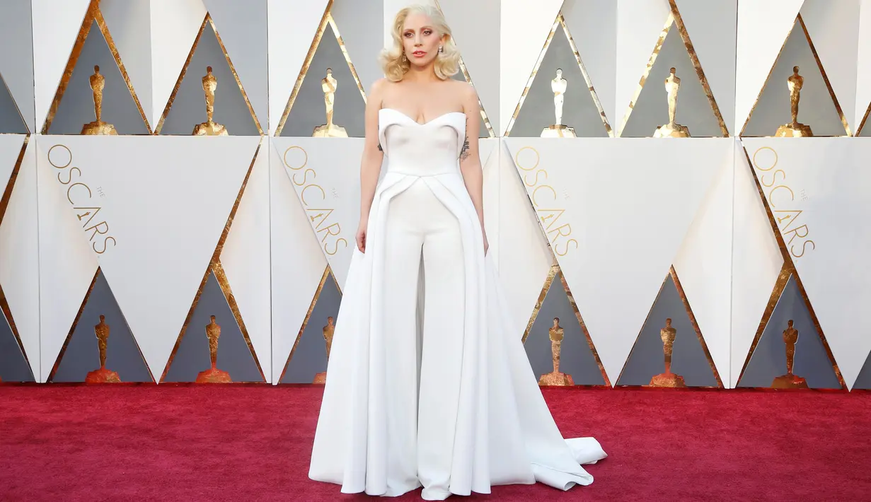 Penyanyi Lady Gaga tampil menyita perhatian pada red carpet Oscar 2016 dalam strapless white pantsuit dengan aksen rok flowing, di Hollywood & Highland Center, Hollywood, California, Minggu (28/2). (REUTERS/Lucy Nicholson)