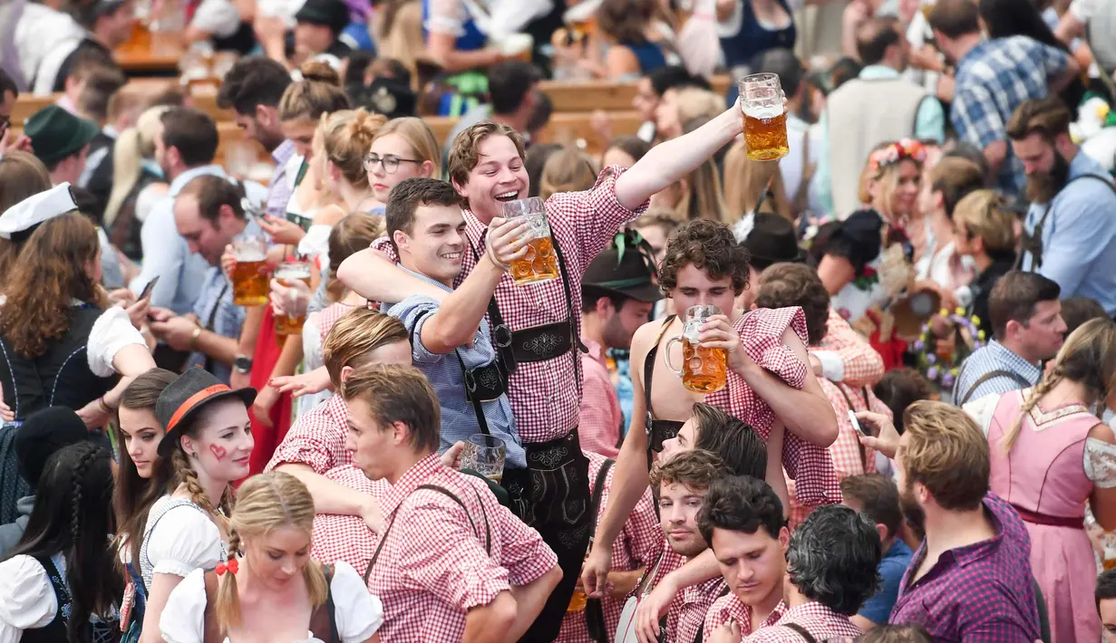 Pengunjung festival Oktoberfest bergembira saat mereka meminum bir di tempat peristirahatan Theresienwiese di Munich, Jerman selatan (24/9). Festival bir terbesar di dunia ini berlangsung sampai 3 Oktober 2017. (AFP Photo/dpa/Tobias Hase/Germany Out)
