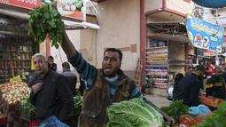 Seorang penjual produk segar Palestina memanggil pelanggan di pasar menjelang buka puasa selama bulan suci Ramadhan di kota Rafah, Jalur Gaza selatan, pada 10 April 2022. (SAID KHATIB / AFP)