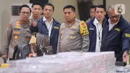Kapolda Metro Jaya Irjen Karyoto (tengah) mengecek barang bukti yang disita terkait kasus dugaan penyalahgunaan wewenang pemblokiran situs judi online yang melibatkan pegawai Kementerian Komunikasi dan Digital (Komdigi). (Liputan6.com/Herman Zakharia)