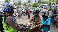 Petugas kepolisian lalu lintas mengecek SIM pengendara motor saat Operasi Zebra Jaya 2020 di kawasan Cawang, Jakarta, Senin (26/10/2020). Operasi Zebra Jaya dilaksanakan pada 26 Oktober-8 November 2020 untuk menekan jumlah pelanggaran lalu lintas. (Liputan6.com/Faizal Fanani)