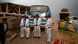 Sejumlah lelaki mengenakan kostum bersiap mengikuti karnaval Anata Andina (Andean karnaval) di Caquiaviri, Bolivia, Selasa (17/1). Dalam acara tersebut sejumlah orang mengenakan kostum dan topeng memenuhi jalan Provinsi Caquiaviri. (AP Photo/Juan Karita)