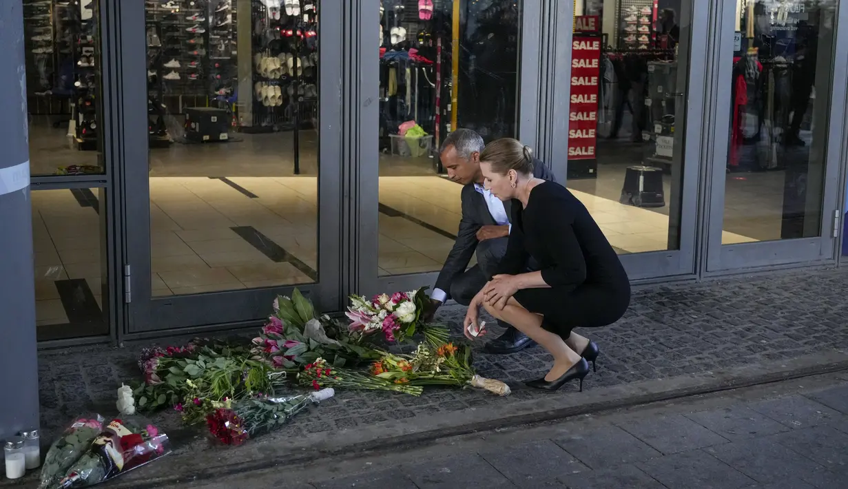 Perdana Menteri Denmark Mette Frederiksen (depan) dan Menteri Kehakiman Mattias Tesfaye meletakkan bunga pada pintu masuk pusat perbelanjaan Field di Kopenhagen, Denmark, 4 Juli 2022. Polisi mengatakan seorang pria bersenjata yang membunuh tiga orang ketika dia melepaskan tembakan di pusat perbelanjaan yang ramai bertindak sendiri dan tampaknya memilih korbannya secara acak. (AP Photo/Sergei Grits)