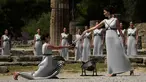 Aktris Yunani, Katerina Lechou, memberikan api olimpiade yang baru saja dinyalakan dalam suatu upacara di Candi Hera yang terletak di bekas kota tua Olympia, Yunani, Kamis (21/4/2016). (AFP/Aris Messinis)