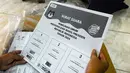 <p>Petugas KPU Kota Tangerang Selatan menunjukkan alat bantu khusus penyandang disabilitas tunanetra untuk Pemilu 2024. (merdeka.com/Arie Basuki)</p>