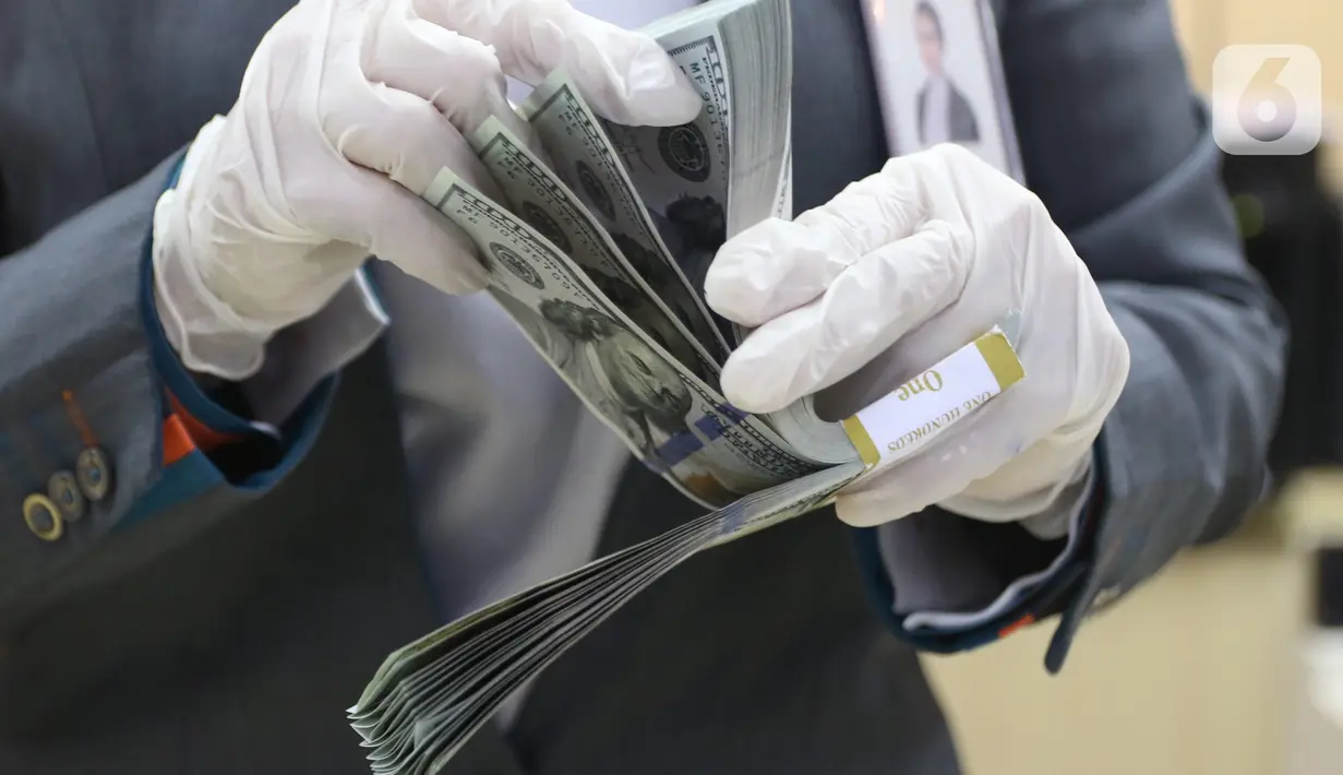 Karyawan bank menghitung uang dolar Amerika Serikat (AS) di Jakarta, Senin (2/11/2020). Nilai tukar rupiah pada perdagangan Senin (2/11) sore ditutup melemah 0,1 persen ke level Rp14.640 per dolar AS, dari perdagangan sebelumnya yaitu Rp14.690 per dolar AS. (Liputan6.com/Angga Yuniar)