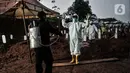 Petugas mengenakan alat pelindung diri (APD) dan baju hazmat saat proses pemakaman pasien Covid-19 di TPU Pondok Ranggon, Jakarta, Kamis (24/9/2020). Jumlah kumulatif kasus Covid-19 di Indonesia mencapai 262.022 orang per Kamis (24/9) dengan 10.105 jiwa meninggal dunia. (merdeka.com/Iqbal Nugroho)
