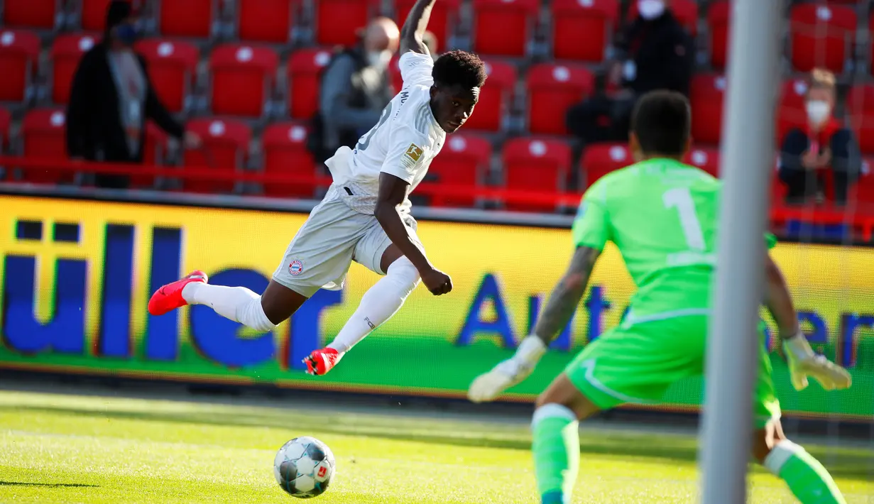 Pemain Bayern Pemain Bayern Munchen Alphonso Davies (kiri) melakukan tembakan ke gawang Union Berlin pada pertandingan Bundesliga di Berlin, Jerman, Minggu (17/5/2020). Bayern Munchen masih memuncaki klasemen Bundesliga usai mengalahkan Union Berlin 2-0. (HANNIBAL HANSCHKE/POOL/AFP)