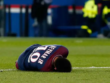 Penyerang PSG, Neymar Jr tergeletak di lapangan setelah mengalami cedera saat bertanding melawan Marseille di Liga Prancis di Stadion Parc des Princes, (25/2). Pergelangan kaki Neymar cedera setelah mendarat dengan tidak pas. (AP Photo/Thibault Camus)