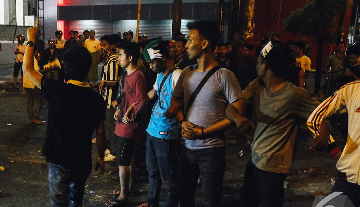 Mahasiswa berunjuk rasa menolak kenaikan BBM di kawasan Cikini, Jakarta, dengan memblokade jalan membentuk pagar manusia, Senin (17/11/2014). (Liputan6.com/Faizal Fanani)