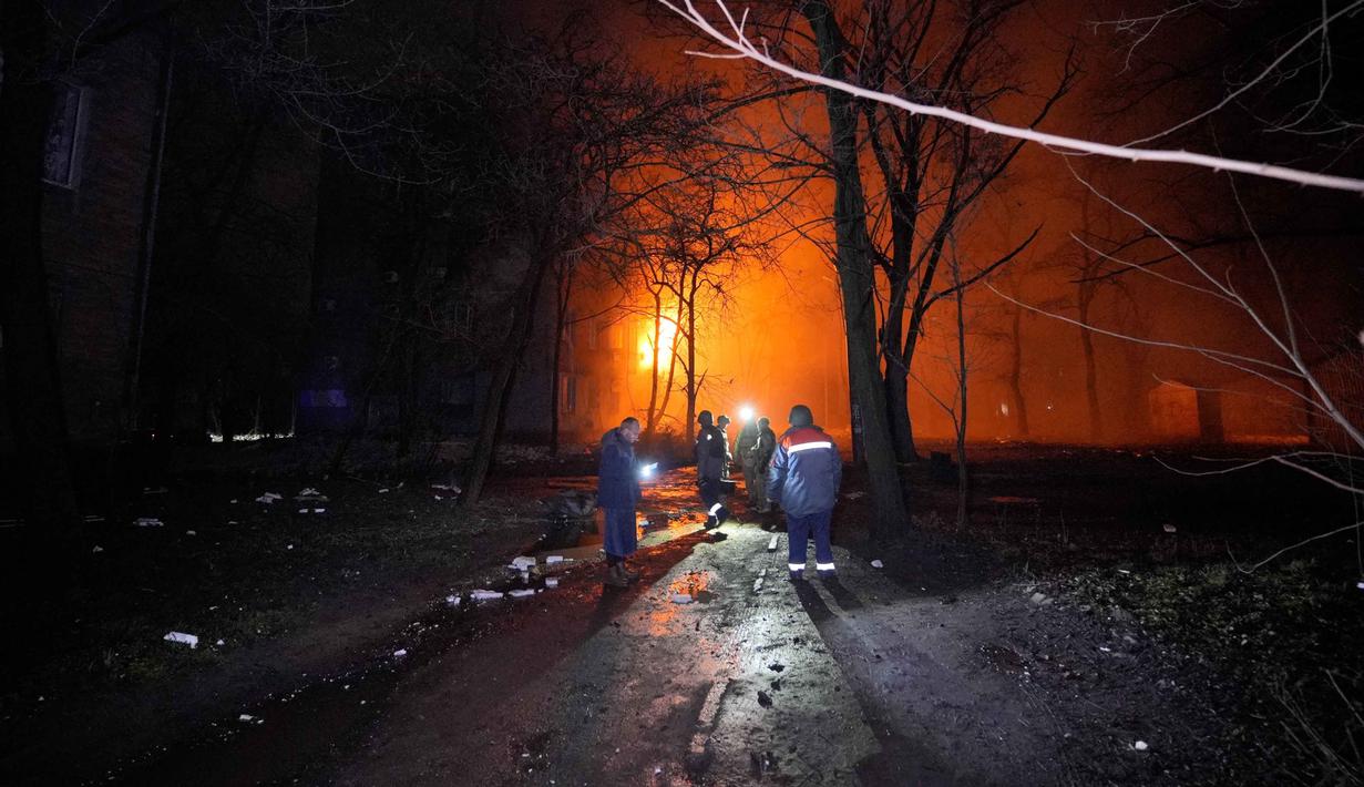 Serangan udara ini menargetkan infrastruktur energi serta menghancurkan sejumlah gedung apartemen warga sipil. Tampak dalam foto, orang-orang berdiri di luar gedung yang terbakar setelah serangan Rusia di Kryvyi Rih, Ukraina, Kamis, 8 Januari 2026. (AP Photo/Mykola Myrnyi)