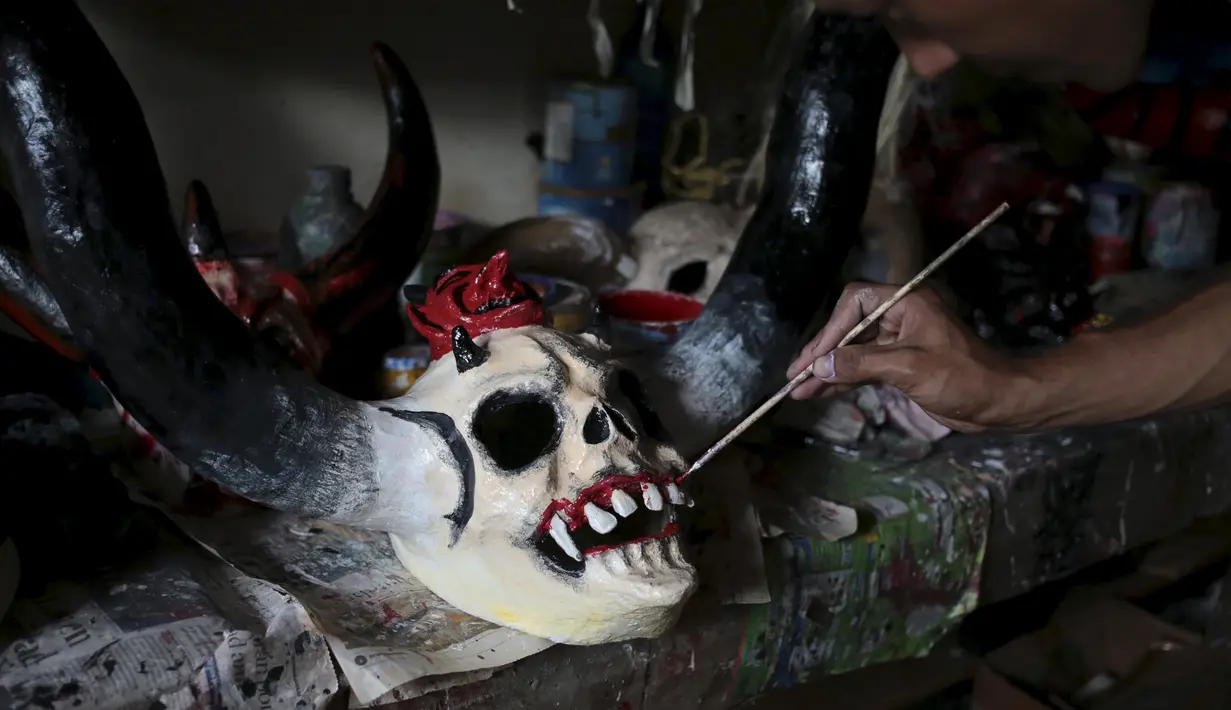Seorang pria saat mewarnai topeng karakter mitologi Nikaragua dalam persiapan menyambut festival Los Aguizotes, Jumat (18/10/2015).  Warga Nikaragua akan berpakaian layaknya karakter dari legenda dan mitologi setempat. (REUTERS/Oswaldo Rivas)