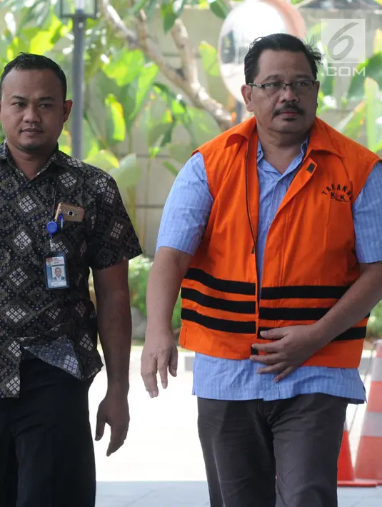 Tersangka Kepala Dinas Pekerjaan Umum (PU) Kabupaten Tulungagung Sutrisno (kanan) tiba di Gedung KPK, Jakarta, Jumat (3/8). Kedatangan Sutrisno untuk menandatangani berkas P21. (Merdeka.com/Dwi Narwoko)