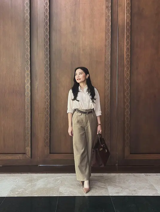 Tampilan work wear yang satu ini dari Prilly Latuconsina juga mudah ditiru. Ia mengenakan kemeja bercorak garis-garis oranye dengan celana panjang cokelat yang serasi, belt, dan heels cokelat senada. [Foto: Instagram/prillylatuconsina96]