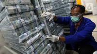 Petugas menata tumpukan uang di Cash Pooling Bank Mandiri, Jakarta, Rabu (20/1/2021). BI mencatat likuiditas perekonomian atau uang beredar dalam arti luas (M2) tetap tinggi pada November 2020 dengan didukung komponen uang beredar dalam arti sempit (M1) dan uang kuasi. (Liputan6.com/Johan Tallo)