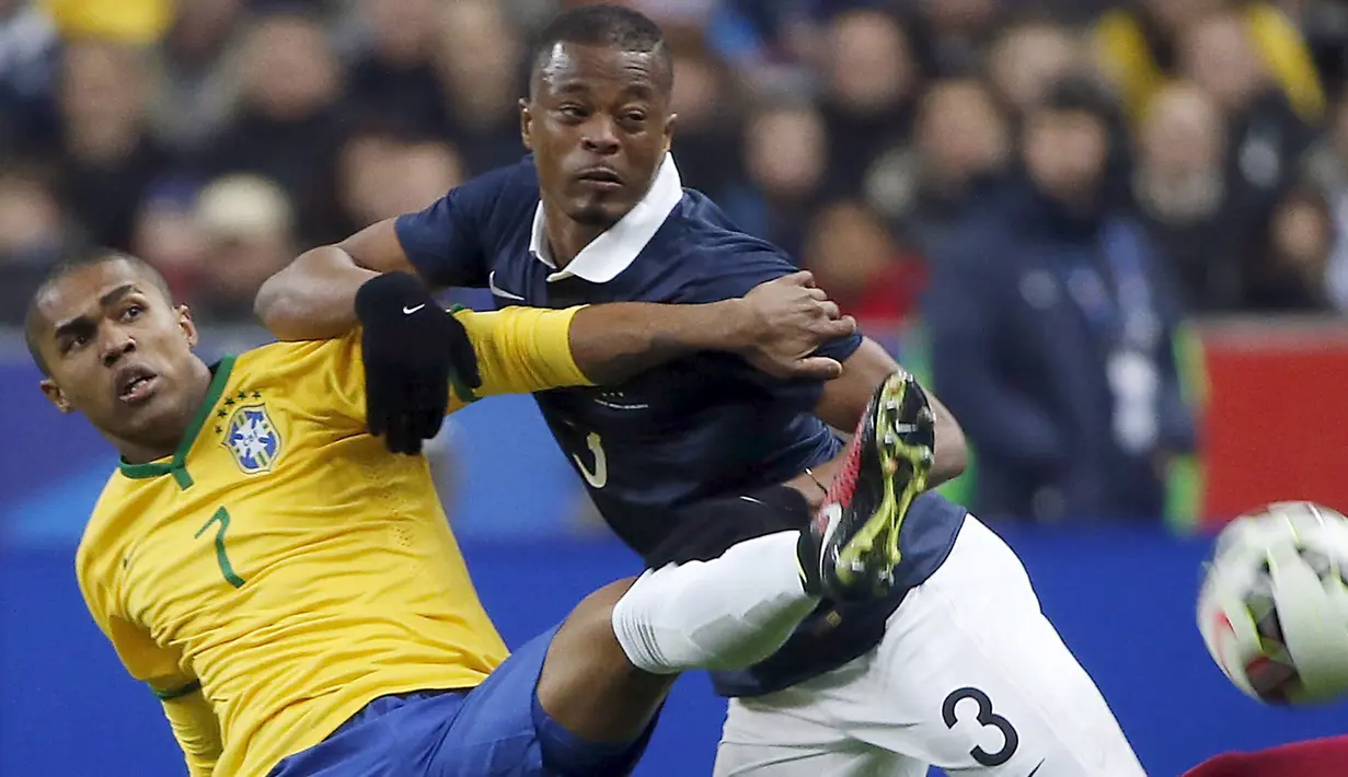 Penyerang Brasil, Douglas Costa (kiri) berebut bola dengan bek Prancis Patrice Evra saat laga persahabatan di Stade de France, Prancis, Jumat (27/3/2015 ). Brasil menang 3-1 atas Prancis. (REUTERS/Charles Platiau)
