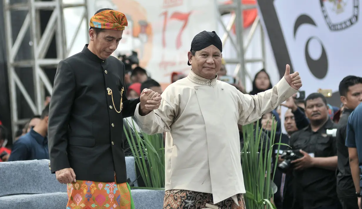Capres nomor urut 01 dan 02, Joko Widodo (kiri) dan Prabowo Subianto bergandengan tangan saat menuruni panggung Deklarasi Kampanye Damai di Monas, Jakarta, Minggu (23/9). Deklarasi menandai dimulainya masa kampanye Pemilu 2019. (Merdeka.com/Iqbal Nugroho)