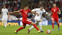 KELABUI - Bomber Timnas Inggris, Wayne Rooney, mengelabui dua pemain bertahan Swiss pada laga lanjutan Grup E kualifikasi Piala Eropa 2016. (Reuters / Carl Recine )