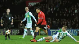 Penyerang MU, Alexis Sanchez berusaha membawa bola dari kawalan gelandang Yeovil Town, Jared Bird pada Piala FA di Huish Park di Yeovil, Somerset (26/1). Sanchez punya kontribusi dalam terciptanya dua gol pertama MU ke gawang Yeovil. (AFP Photo)