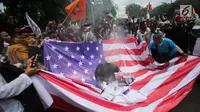 Massa aksi melakukan unjuk rasa dengan membakar bendera Amerika Serikat (AS) di depan Kedubes AS, Jakarta, Senin (11/12). Massa dari berbagai organisasi masyarakat itu juga menuntut agar Duta Besar AS hengkang dari Indonesia. (Liputan6.com/Faizal Fanani)