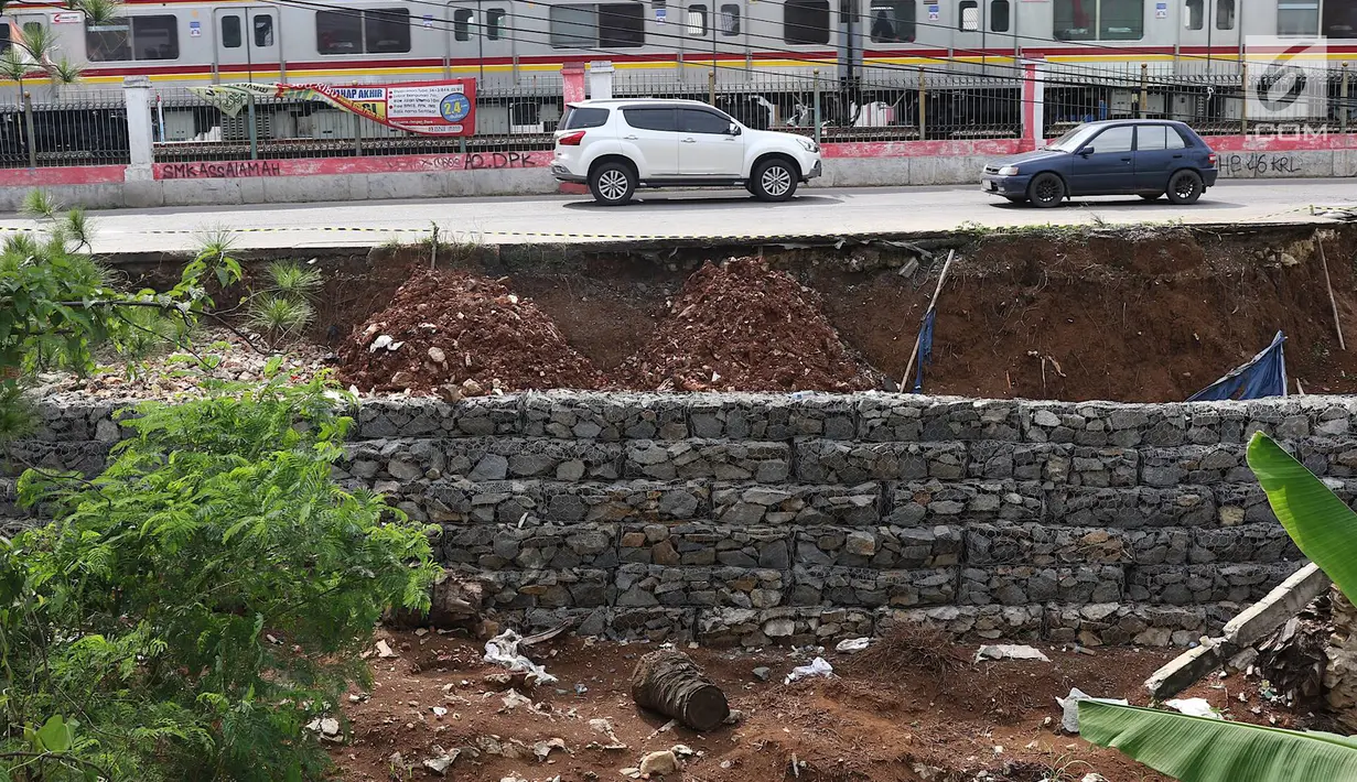 Kendaraan melintas di samping Jalan Raya Citayam yang amblas di kawasan Cipayung, Depok, Jawa Barat, Rabu (27/2). Kondisi tepi jalan yang tidak kunjung diperbaiki membahayakan pengguna jalan terutama saat malam hari. (Liputan6.com/Immanuel Antonius)
