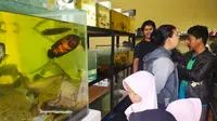 Nampak Mansyahlan, tengah melayani beberapa pengunjung yang datang ke kios ikan hiasnya yang berada di bilangan jalan  Karangpawitan, Garut, Jawa Barat. (Liputan6.com/Jayadi Supriadin)