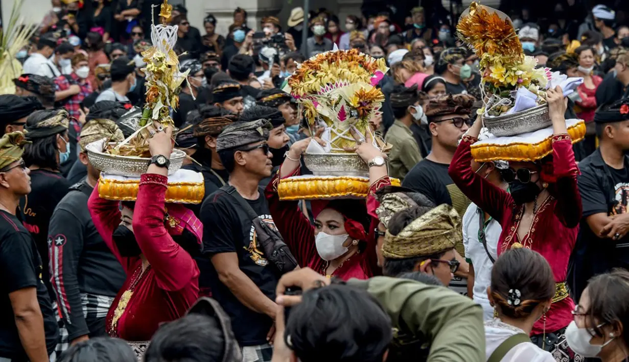 Orang-orang membawa sesaji saat upacara ngaben untuk mendiang Raja Ida Cokorda Pemecutan XI atau Anak Agung Ngurah Manik Parasara di Denpasar, Bali, 21 Januari 2022. Anak Agung Ngurah Manik Parasara meninggal pada Desember lalu di usia 76 tahun. (SONY TUMBELAKA/AFP)