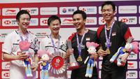 Ganda putra Indonesia  Mohammad Ahsan/Hendra Setiawan berpose dengan Hiroyuki Endo/Yuta Watanabe dari Jepang usai meraih juara BWF World Tour Finals 2019 di Tianhe Gymnasium, Guangzhou (15/12/2019).  Ahsan/Hendra menang  24-22, 21-19.  (AP Photo/Andy Wong)