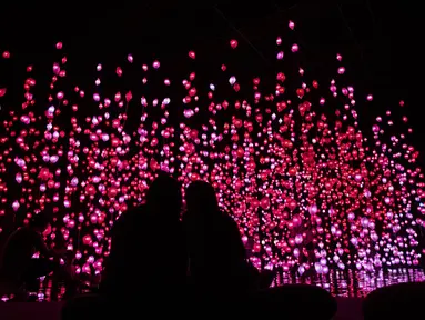 Orang-orang mengunjungi "Pixel Forest" oleh seniman Swiss Pipilotti Rist, sebuah instalasi seni dari 3000 lampu LED pahatan tangan yang digantung di langit-langit di Tai Kwun di Hong Kong (18/8/2022). (AFP/Isaac Lawrence)