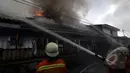 Api berkobar di atas rumah penduduk di kawasan Pasar Kembangan, Senen. Tampak petugas sedang berusaha memadamkan api, Jakarta, Senin(19/1/2015).  (Liputan6.com/Miftahul Hayat)