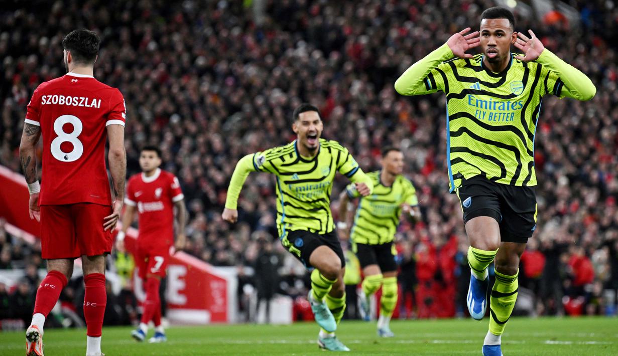 Pemain Arsenal, Gabriel Magalhaes, melakukan selebrasi setelah mencetak gol gol ke gawang Liverpool pada laga pekan ke-18 Premier League 2023/2024 di Stadion Anfield, Minggu (24/12/2023). Hasil ini membuat The Gunners tetap bertengger di puncak klasemen Liga Inggris dengan mengumpulkan 40 poin dari 18 laga. (AFP/Paul Ellis)