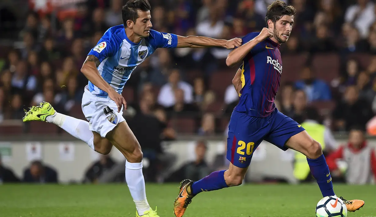 Bek Malaga, Luis Hernandez, mencoba menahan laju gelandang Barcelona, Sergi Roberto, pada laga La Liga di Stadion Camp Nou, Barcelona, Sabtu (21/10/2017). Barcelona menang 2-0 atas Malaga. (AFP/Josep Lago)