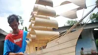Seorang perajin menghaluskan miniatur perahu pinisi yang terbuat dari bambu di sentra kerajinan bambu Desa Kelapa Sawit, Kalimanah, Purbalingga, Jateng. (Antara)