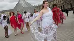 Seorang model ukuran plus berpose di depan piramida Louvre di Paris, Prancis (4/1). Mereka tampil di ruang publik dengan menggunakan busana layaknya di sebuah acara fashion show. (AFP/Thomas Samson)