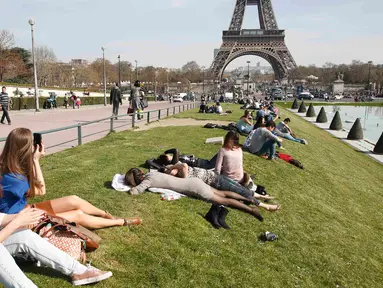 Wisatawan menikmati musim semi yang hangat dan cerah di Trocadero square di dekat menara Eiffel, Paris, Kamis (9/4/2015). (REUTERS/Charles Platiau)