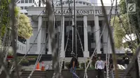 Pewarta berjalan melintasi halaman depan Gedung Mahkamah Konstitusi, Jakarta, Kamis (13/6/2019). Mahkamah Konstitusi akan menggelar sidang Perselisihan Hasil Pemilihan Presiden/Wakil Presiden Pemilu 2019 pada, Jumat (14/6). (Liputan6.com/Helmi Fithriansyah)