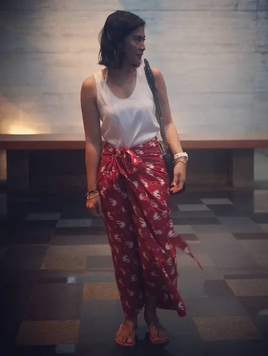 Perempuan yang juga hobi bergelut di dunia teater ini tampak sederhana dengan kain ikat berwarna merah dan atasan tank top. Terlihat seksi, namun tidak berlebihan. (Instagram/therealdisastr)